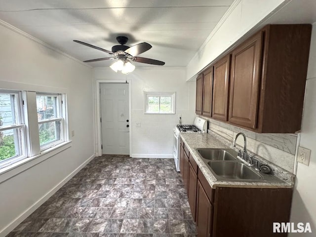 410 E Thrush Ave, Peoria, IL 61603 - kitchen featuring white gas range oven, a sink, ornamental molding, a ceiling fan, and baseboards