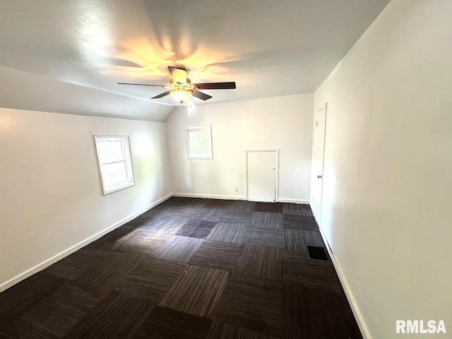 410 E Thrush Ave, Peoria, IL 61603 - unfurnished room with dark colored carpet, a ceiling fan, vaulted ceiling, and baseboards