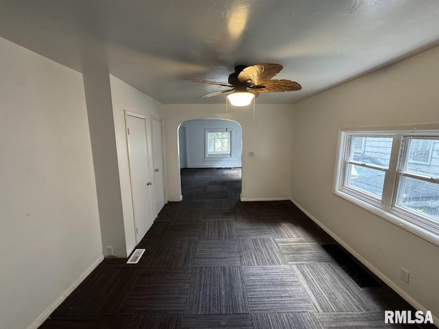 410 E Thrush Ave, Peoria, IL 61603 - unfurnished room featuring arched walkways, ceiling fan, and baseboards
