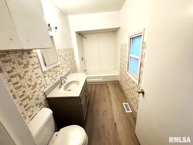410 E Thrush Ave, Peoria, IL 61603 - bathroom featuring toilet, vanity, wood finished floors, and bathtub / shower combination