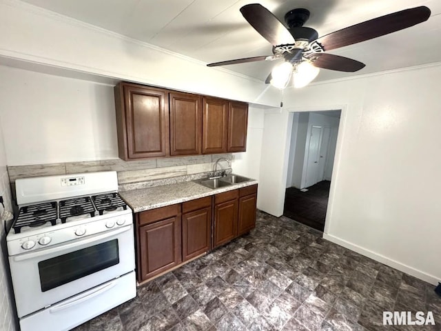410 E Thrush Ave, Peoria, IL 61603 - kitchen with white gas range, a sink, light countertops, crown molding, and ceiling fan