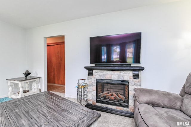 1202 W Purtscher Dr, Peoria, IL 61614 - living room featuring carpet flooring, a stone fireplace, and baseboards
