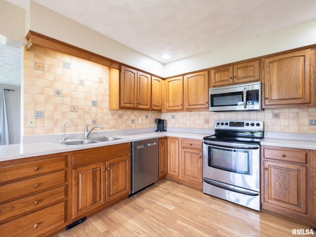 26620 Schuck Rd, Washington, IL 61571 - kitchen featuring stainless steel appliances, a sink, brown cabinetry, and backsplash