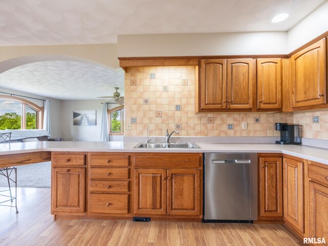 26620 Schuck Rd, Washington, IL 61571 - kitchen featuring stainless steel dishwasher, a sink, a ceiling fan, brown cabinets, and arched walkways