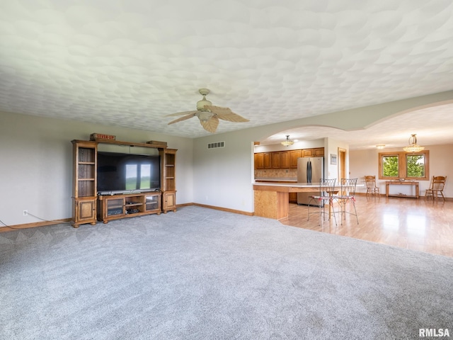 26620 Schuck Rd, Washington, IL 61571 - unfurnished living room featuring arched walkways, baseboards, ceiling fan, and light colored carpet