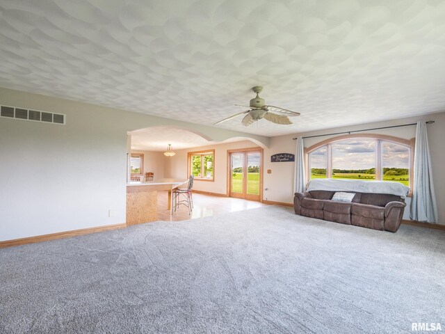 26620 Schuck Rd, Washington, IL 61571 - living room featuring arched walkways, baseboards, light colored carpet, and ceiling fan