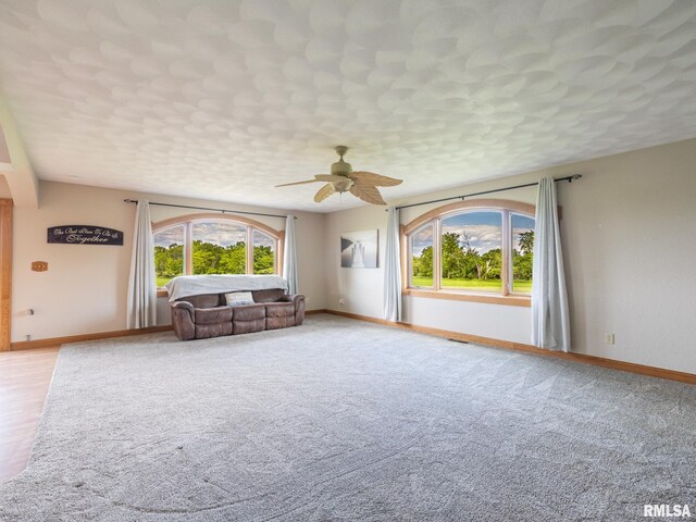 26620 Schuck Rd, Washington, IL 61571 - unfurnished living room featuring healthy amount of natural light, ceiling fan, baseboards, and light carpet