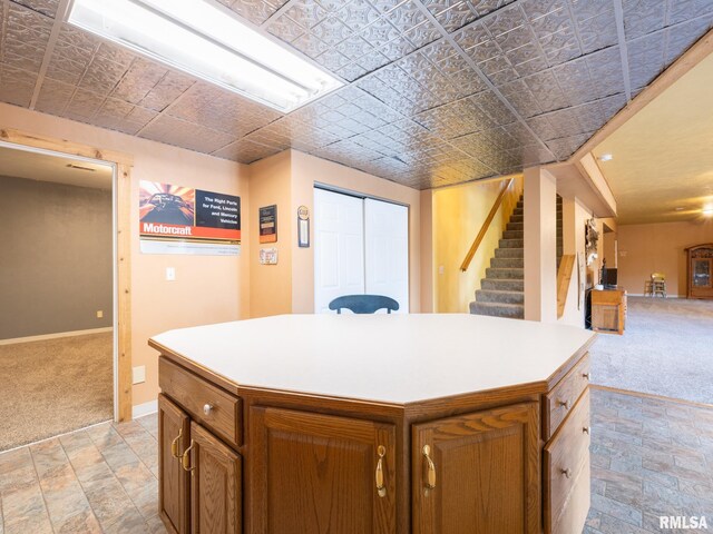 26620 Schuck Rd, Washington, IL 61571 - kitchen featuring light colored carpet, baseboards, a center island, light countertops, and an ornate ceiling