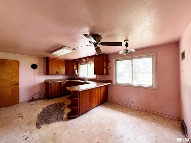 9333 S Powell Rd, Peoria, IL 61607 - kitchen with open shelves, brown cabinets, and a peninsula