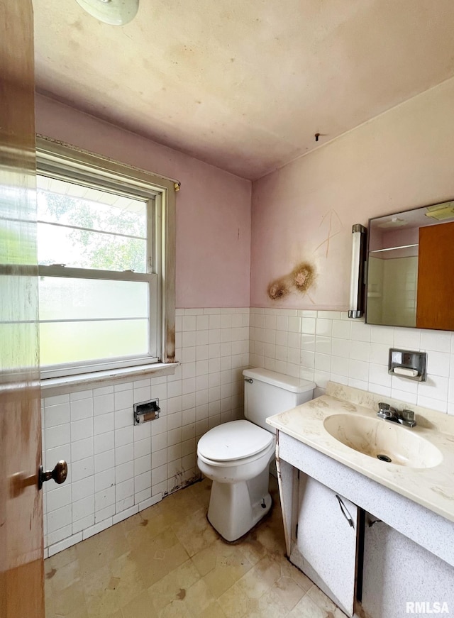 9333 S Powell Rd, Peoria, IL 61607 - bathroom featuring tile walls, toilet, vanity, and a wainscoted wall