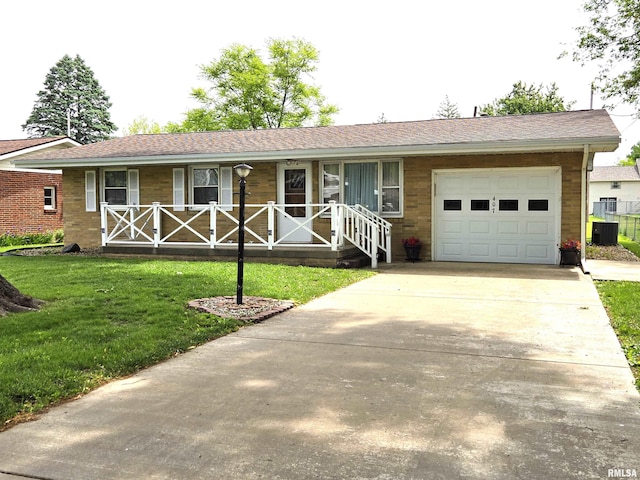 407 N 12th Ave, Canton, IL 61520 - ranch-style house featuring covered porch, a garage, a front yard, and driveway