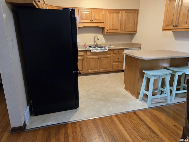 407 N 12th Ave, Canton, IL 61520 - kitchen with freestanding refrigerator, a sink, light countertops, dishwasher, and a breakfast bar