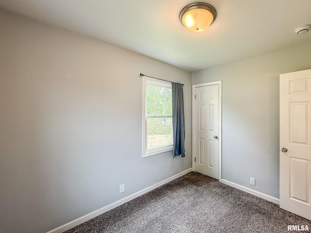 311 N 5th St, Chillicothe, IL 61523 - unfurnished bedroom with baseboards and dark carpet