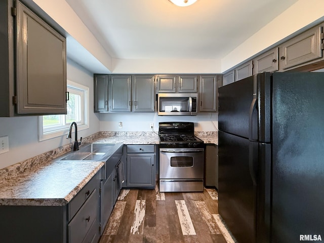311 N 5th St, Chillicothe, IL 61523 - kitchen featuring stainless steel appliances, gray cabinets, a sink, dark wood finished floors, and light countertops