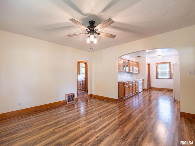 110 Loren St, Washington, IL 61571 - unfurnished living room with arched walkways, ceiling fan, dark wood-type flooring, and baseboards