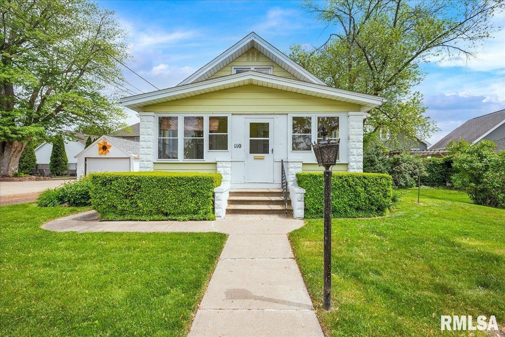 110 N 4th Ave, Morton, IL 61550 - view of front of house with a front lawn and a garage