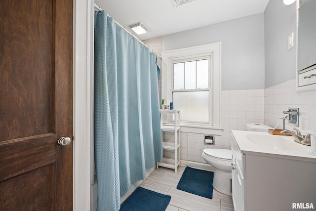 1006 N Maplewood Ave, Peoria, IL 61606 - full bathroom with tile walls, vanity, toilet, wainscoting, and tile patterned floors