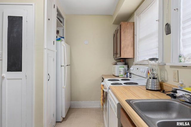 1006 N Maplewood Ave, Peoria, IL 61606 - kitchen featuring white appliances, a sink, light countertops, baseboards, and brown cabinetry