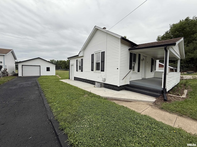 210 Minch St, South Pekin, IL 61564 - view of side of home with a porch, a lawn, an outdoor structure, a detached garage, and driveway
