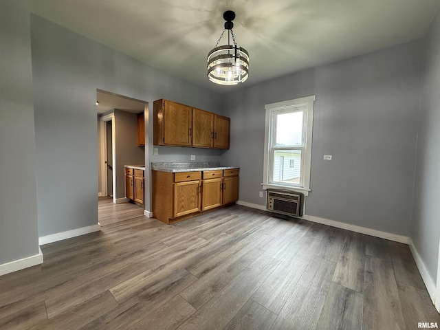 210 Minch St, South Pekin, IL 61564 - kitchen with brown cabinetry, a chandelier, a wall unit AC, dark wood-style flooring, and light countertops