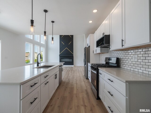 112 Shannon Hills Dr, Washington, IL 61571 - kitchen featuring stainless steel appliances, a sink, tasteful backsplash, light wood-style floors, and light countertops