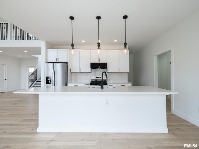 112 Shannon Hills Dr, Washington, IL 61571 - kitchen featuring stainless steel appliances, a sink, a center island with sink, light countertops, and white cabinetry