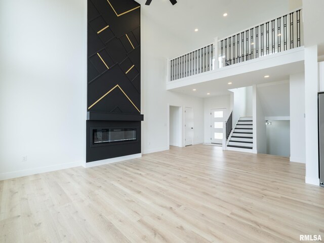 112 Shannon Hills Dr, Washington, IL 61571 - unfurnished living room with stairway, a high ceiling, wood finished floors, a fireplace, and baseboards