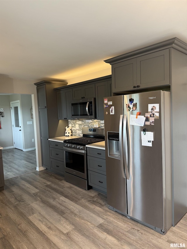 4170 E 1200th St, Macomb, IL 61455 - kitchen featuring appliances with stainless steel finishes, gray cabinets, light countertops, wood finished floors, and decorative backsplash