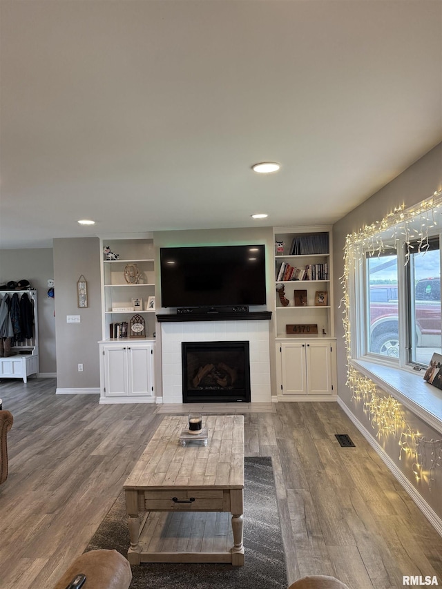 4170 E 1200th St, Macomb, IL 61455 - living area featuring baseboards, wood finished floors, a fireplace, and built in shelves