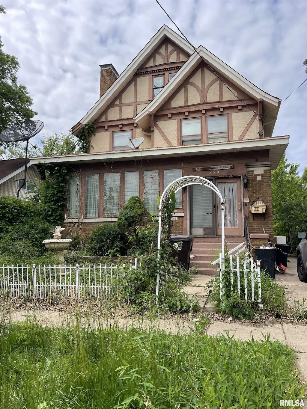 209 E Arcadia Ave, Peoria, IL 61603 - tudor home with a chimney, stucco siding, and brick siding