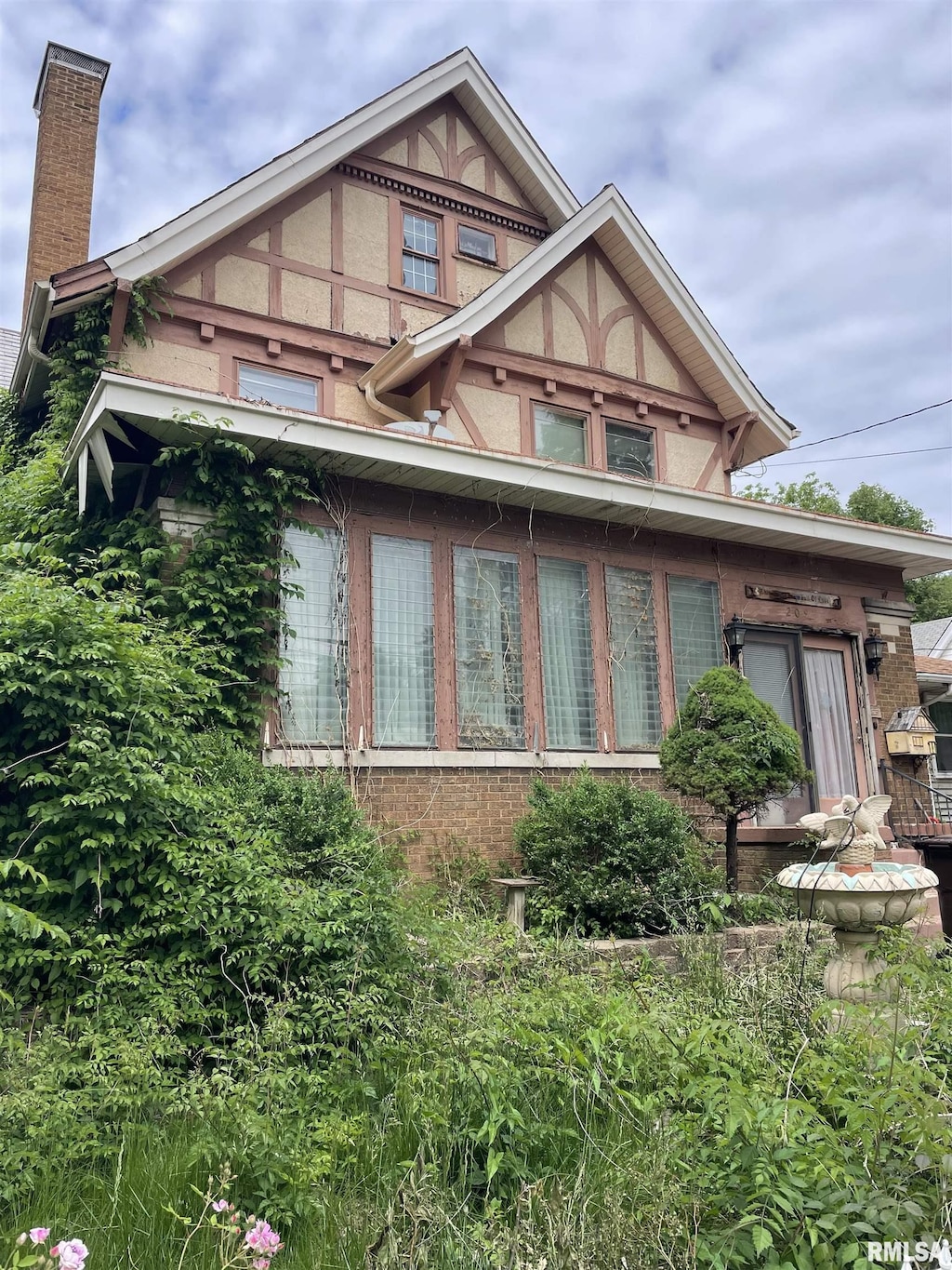 209 E Arcadia Ave, Peoria, IL 61603 - view of side of property featuring a chimney, stucco siding, and brick siding