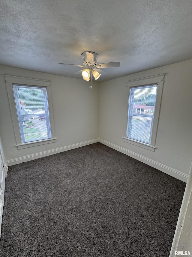 60 E Ash St, Canton, IL 61520 - spare room with healthy amount of natural light, dark colored carpet, a textured ceiling, and a ceiling fan