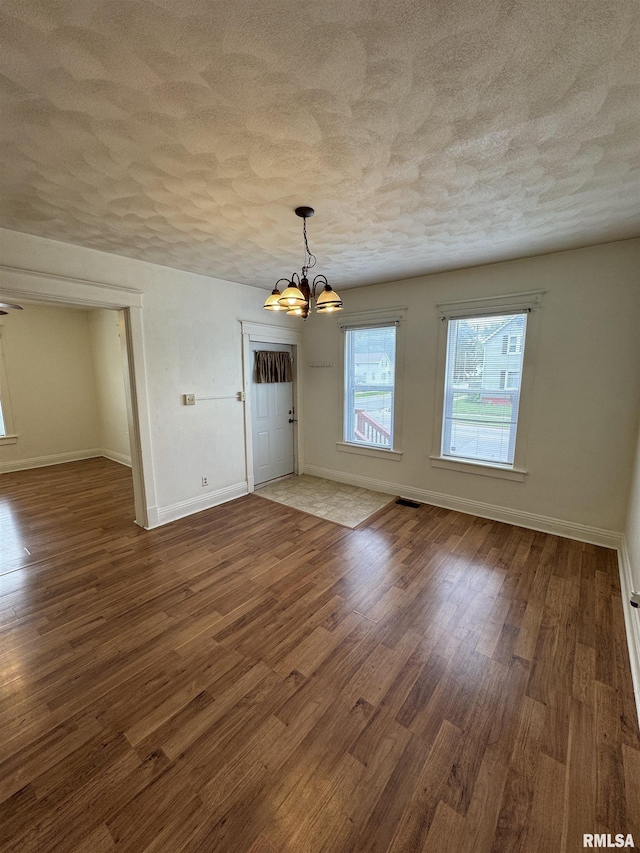 60 E Ash St, Canton, IL 61520 - unfurnished dining area with a textured ceiling, a chandelier, and wood finished floors