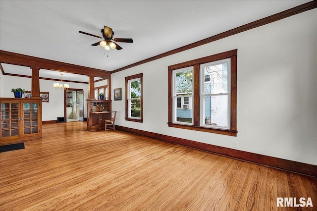 2623 W Ardmore Pl, West Peoria, IL 61604 - unfurnished living room with a chandelier, baseboards, light wood-style flooring, crown molding, and ceiling fan