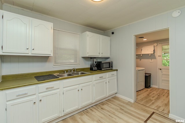 153 Hollywood Cir, Creve Coeur, IL 61610 - kitchen featuring a sink, stainless steel microwave, washing machine and clothes dryer, crown molding, and light wood finished floors