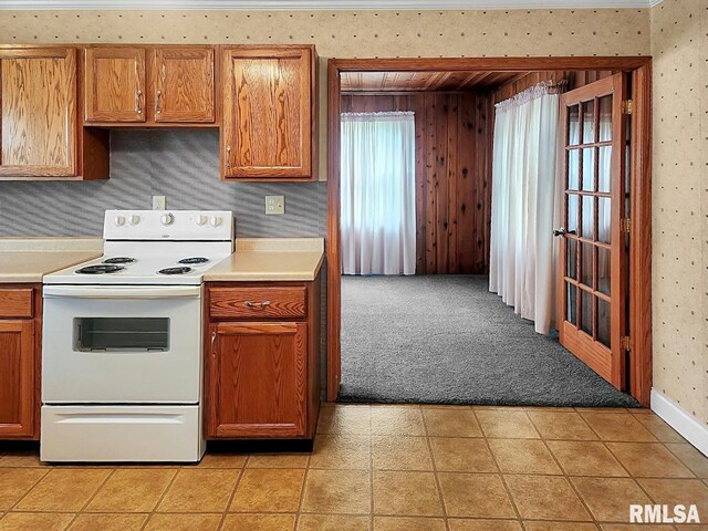 419 S Franklin St, Toulon, IL 61483 - kitchen featuring white electric range oven, wallpapered walls, light countertops, brown cabinetry, and light carpet