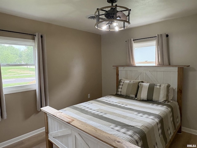 606 Lasalle Blvd, Marquette Heights, IL 61554 - bedroom featuring baseboards, multiple windows, a chandelier, and wood finished floors