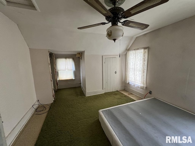 102 W 1st St, Table Grove, IL 61482 - unfurnished bedroom with vaulted ceiling, carpet flooring, a ceiling fan, and baseboards
