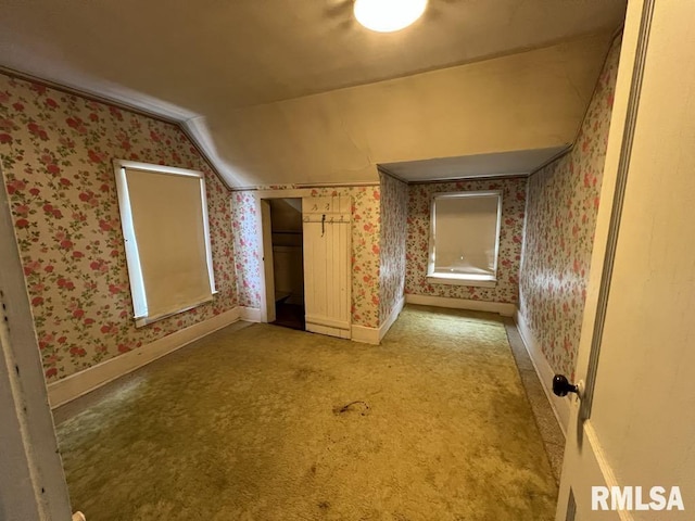 102 W 1st St, Table Grove, IL 61482 - empty room with vaulted ceiling, wallpapered walls, baseboards, and light colored carpet