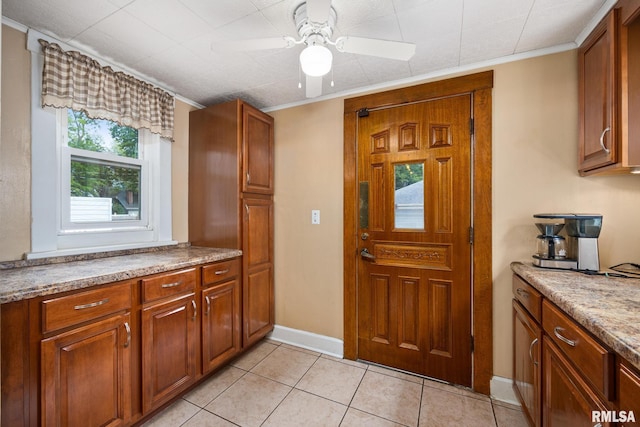 1614 W Columbia Ter, Peoria, IL 61606 - kitchen featuring a ceiling fan, light tile patterned floors, brown cabinetry, and crown molding