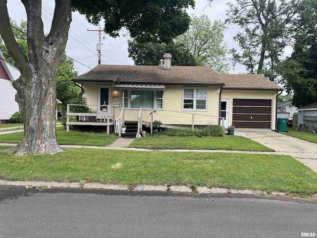 313 N Edwards St, Macomb, IL 61455 - view of front of home with a garage, a front yard, driveway, a chimney, and covered porch