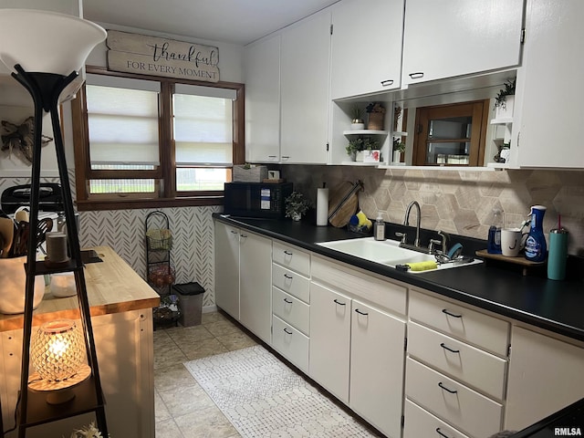 313 N Edwards St, Macomb, IL 61455 - kitchen featuring a sink, open shelves, black microwave, backsplash, and white cabinetry