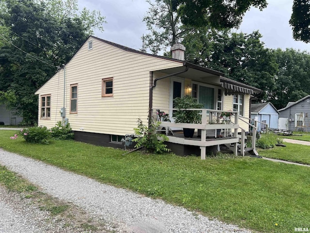 313 N Edwards St, Macomb, IL 61455 - view of home's exterior with a yard, a wooden deck, a chimney, and an outbuilding