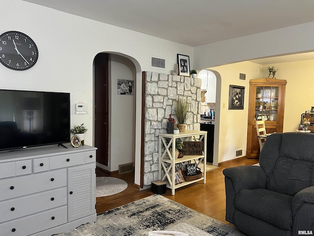 313 N Edwards St, Macomb, IL 61455 - living area with arched walkways, wood finished floors, and baseboards