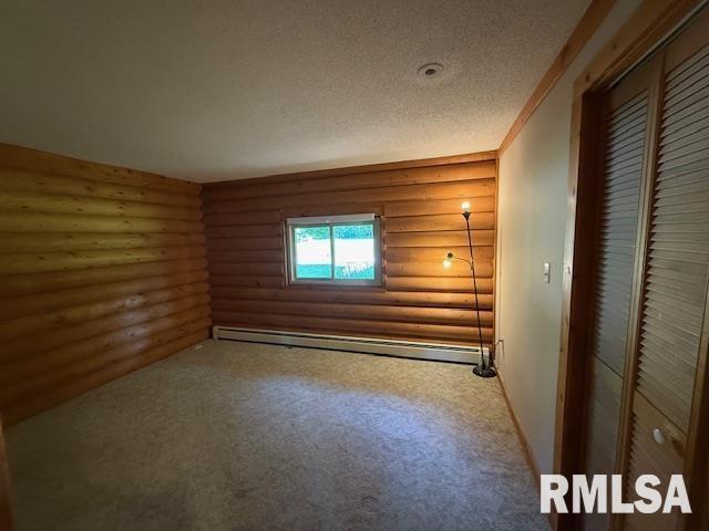 1 Marty Ln, Macomb, IL 61455 - full bathroom featuring a baseboard heating unit, vanity, a textured ceiling, toilet, and log walls