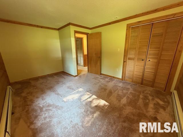 1 Marty Ln, Macomb, IL 61455 - spare room with a textured ceiling, a baseboard heating unit, wood finished floors, and rustic walls