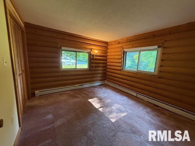 1 Marty Ln, Macomb, IL 61455 - unfurnished bedroom featuring baseboard heating, a closet, ornamental molding, carpet flooring, and baseboards
