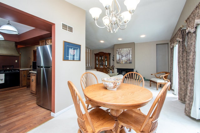 32 Black Partridge Run, Hopewell, IL 61565 - dining area featuring a chandelier, recessed lighting, a fireplace, and light wood finished floors