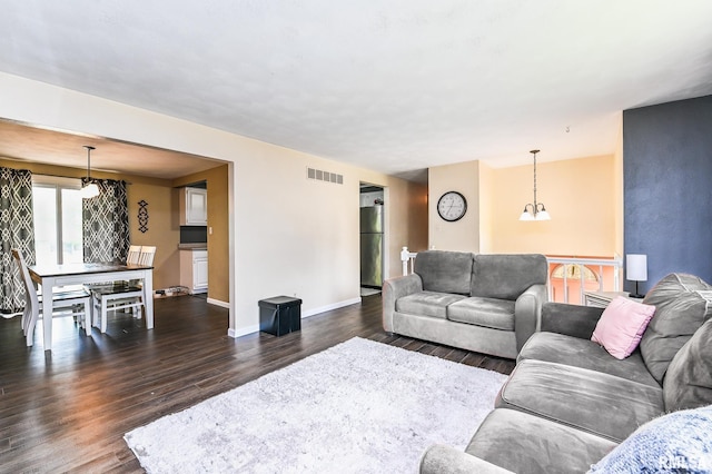 311 Juniper Ln, East Peoria, IL 61611 - living room with dark wood-style flooring, baseboards, and a chandelier