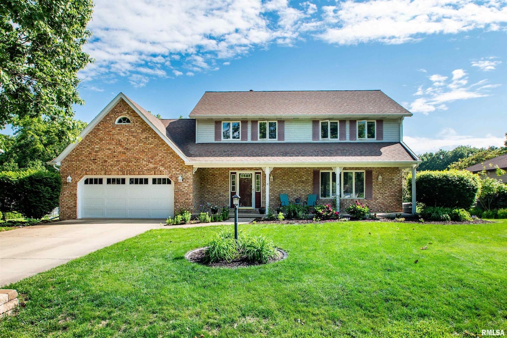 314 E White Oak Ct, East Peoria, IL 61611 - traditional-style home with an attached garage, concrete driveway, a front yard, and brick siding